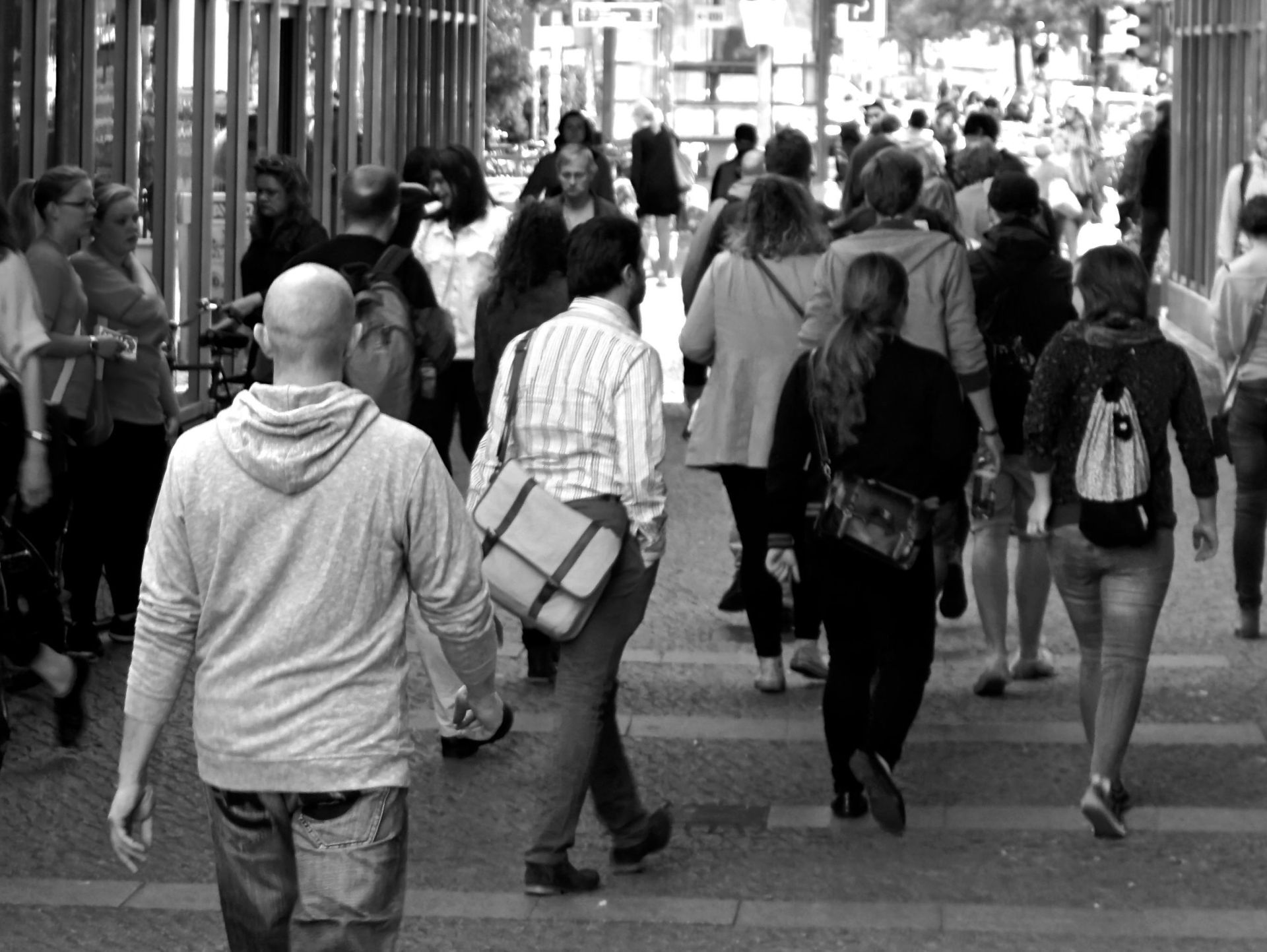A bustling street scene capturing diverse pedestrians walking outdoors in an urban setting.