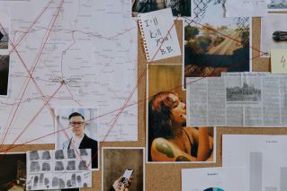 A detailed crime investigation board with photos, maps, and red threads used for connecting clues.